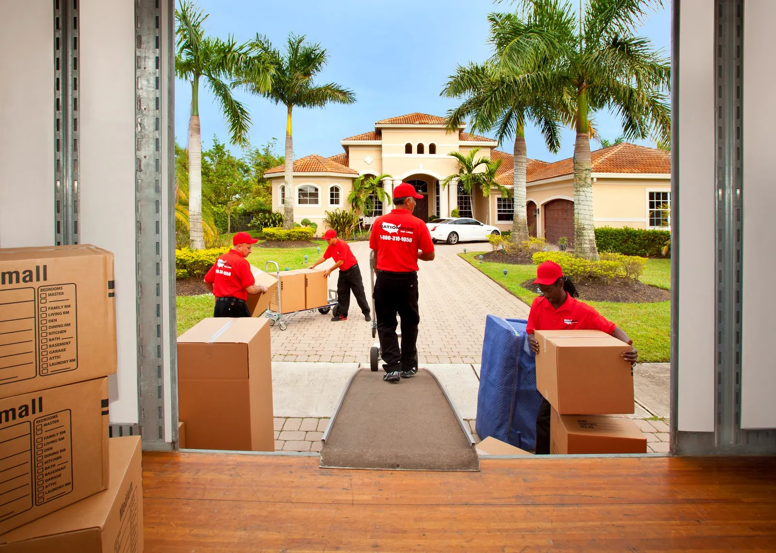 Nationwide Van Lines crew carrying wrapped furniture from a Florida home into the truck