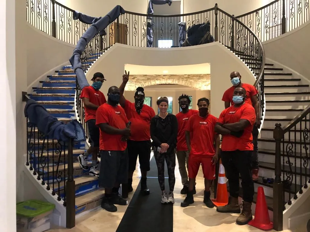 Nationwide Van Lines crew posing with a customer in a grand foyer
