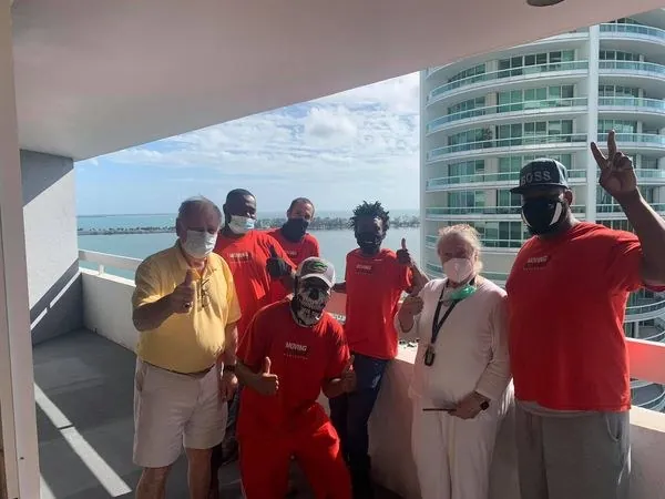 Nationwide crew with customers on a high-rise balcony over Biscayne Bay