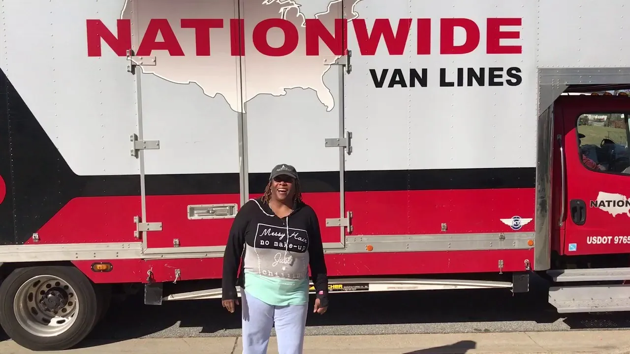 Customer in front of a red Nationwide Van Lines semi truck